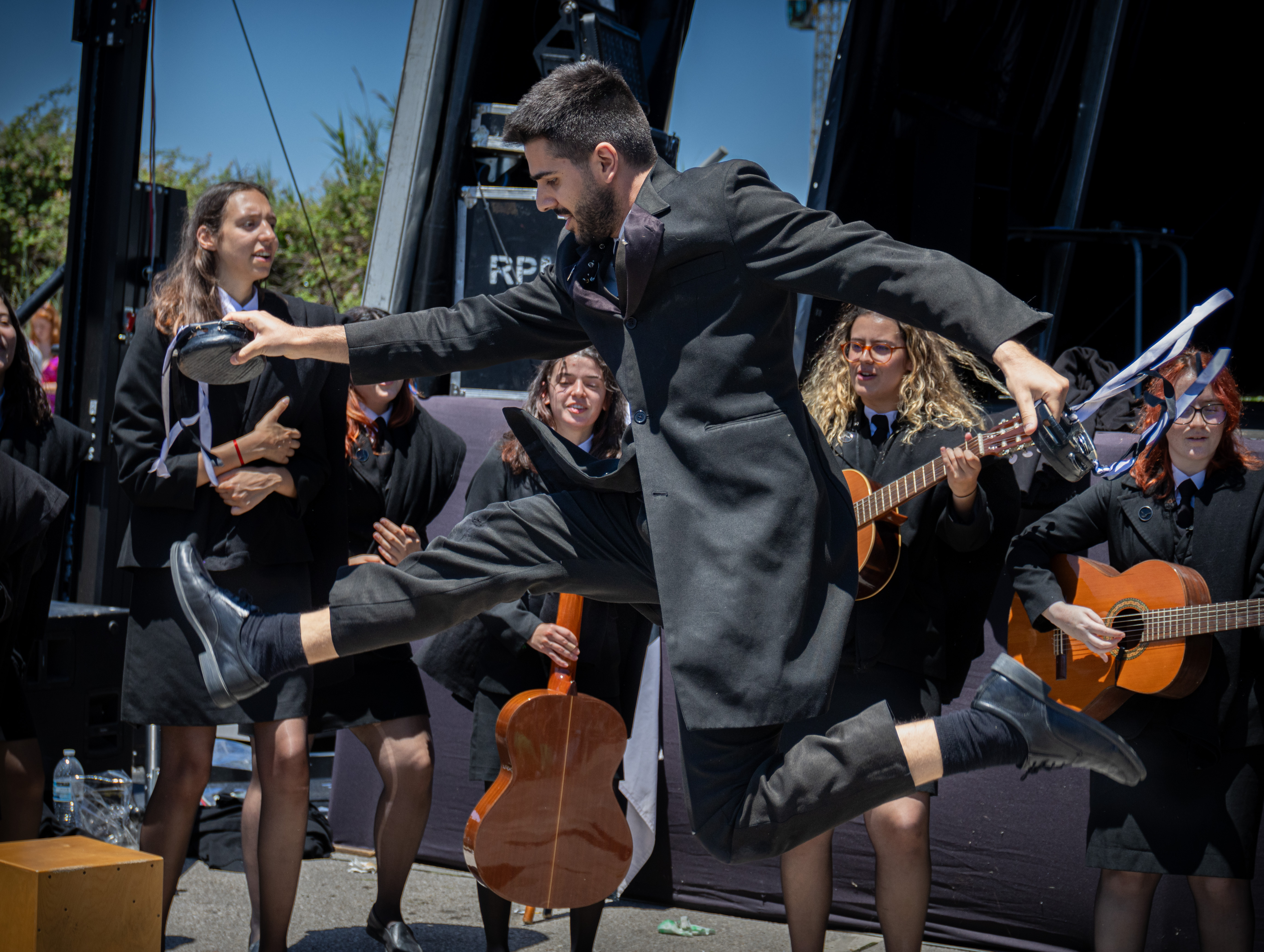 Guy holding tambourines while jumping